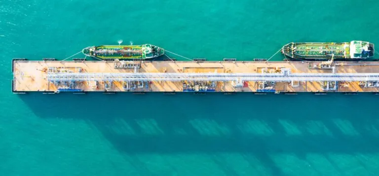 Aerial view tanker ship unloading at port, Business import export oil with tanker ship transportation oil from refinery on the sea.